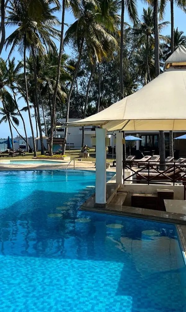 Swim-up pool bar with submerged stools at Kenya Bay Beach Hotel